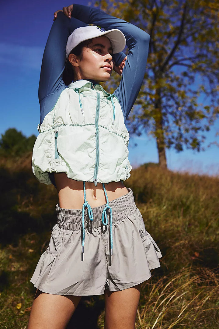 Get Your Flirt On Shorts in sage stone, worn by a model in an outdoor setting.