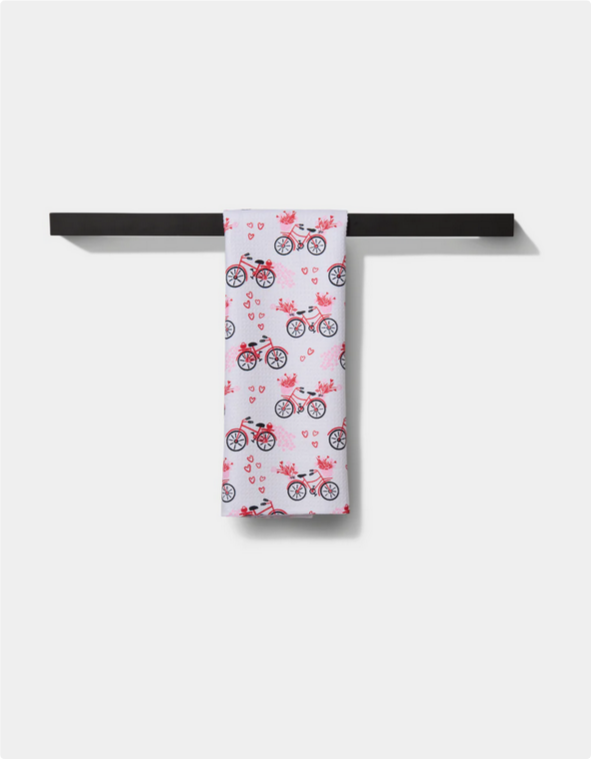 Love Bikes Tea Towel with a pattern of red bicycles and hearts.