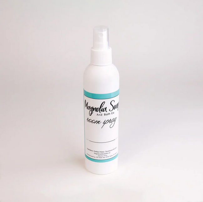 White Magnolia Soap and Bath Co. room spray bottle with a teal label.