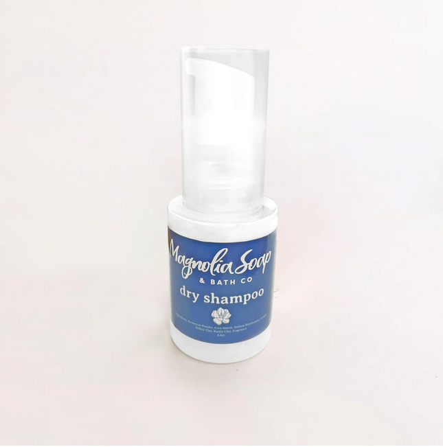 A white bottle of Magnolia Soap & Bath Co dry shampoo with a clear cap.