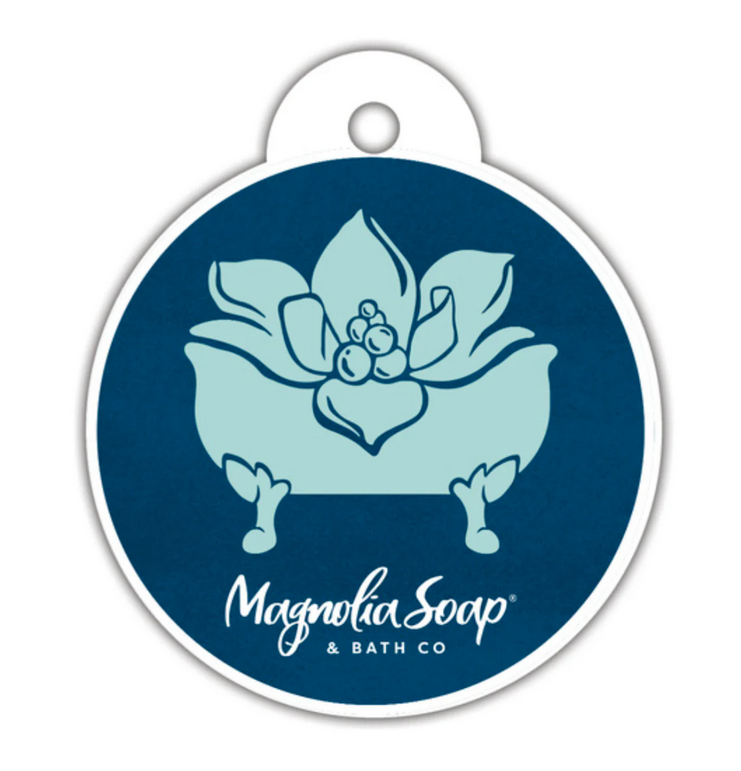 A round, dark blue car freshie features a light blue magnolia flower in a clawfoot tub.