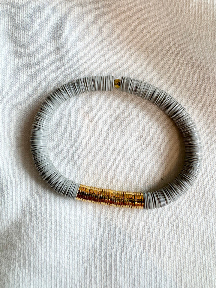A large flat bead bracelet with gray vinyl beads and a section of gold-plated beads.