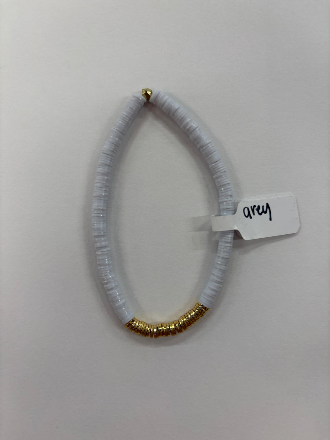 Small flat bead bracelet with white beads and a section of gold-plated beads.