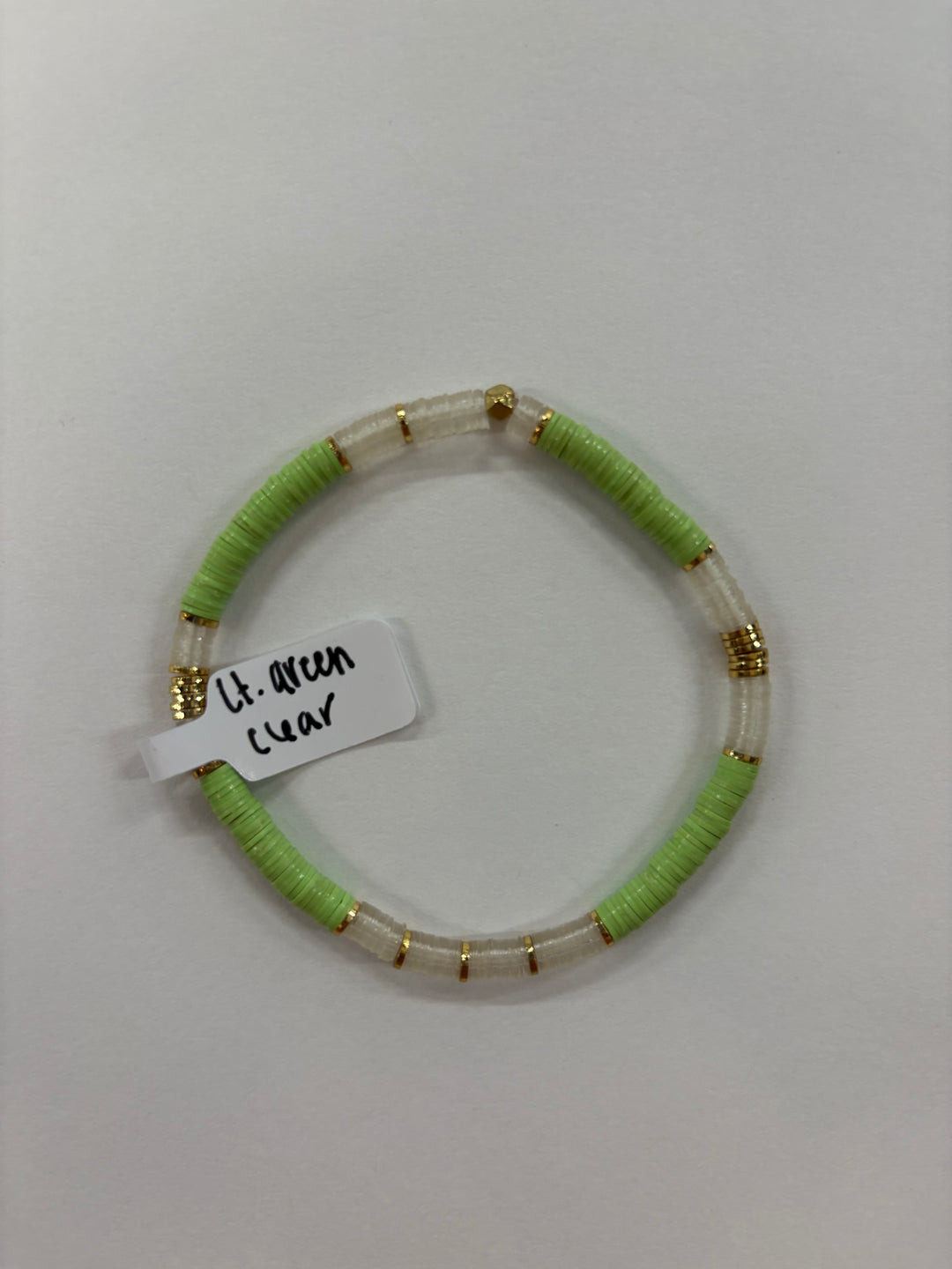 A light green and clear flat bead bracelet with gold accents.