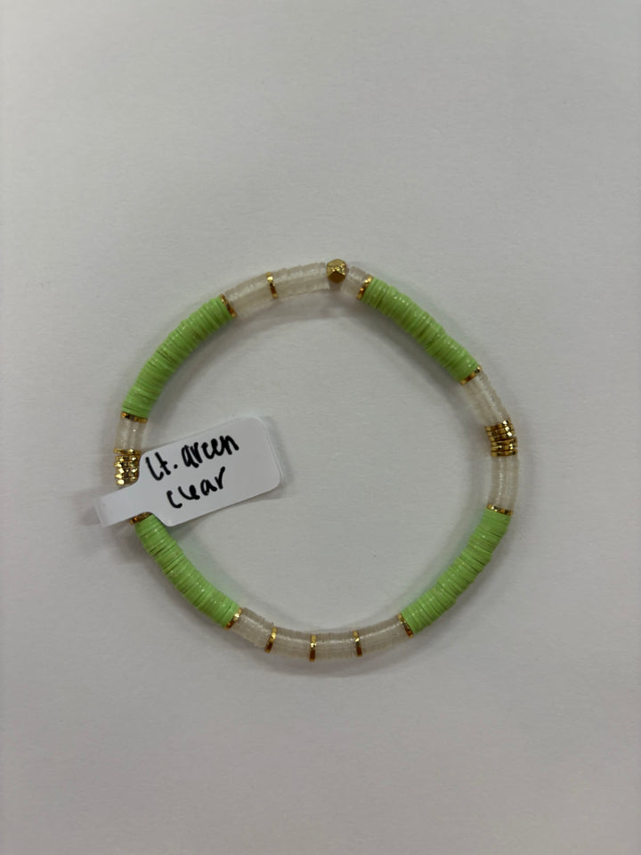 A light green and clear flat bead bracelet with gold accents.