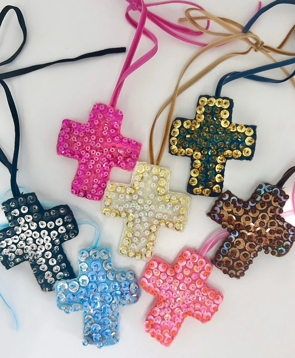 Seven mini cross ornaments, each hand-beaded with sequins in various colors.