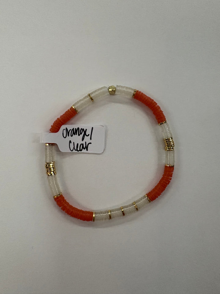 A small flat bead bracelet with orange and clear beads and gold accents.
