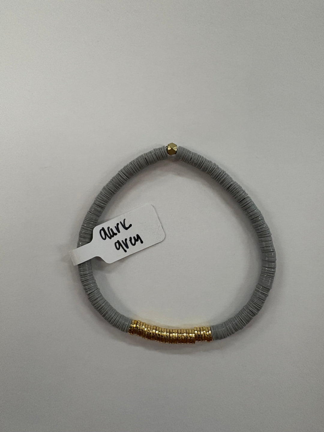 Small flat bead bracelet in dark grey with gold-plated accents.