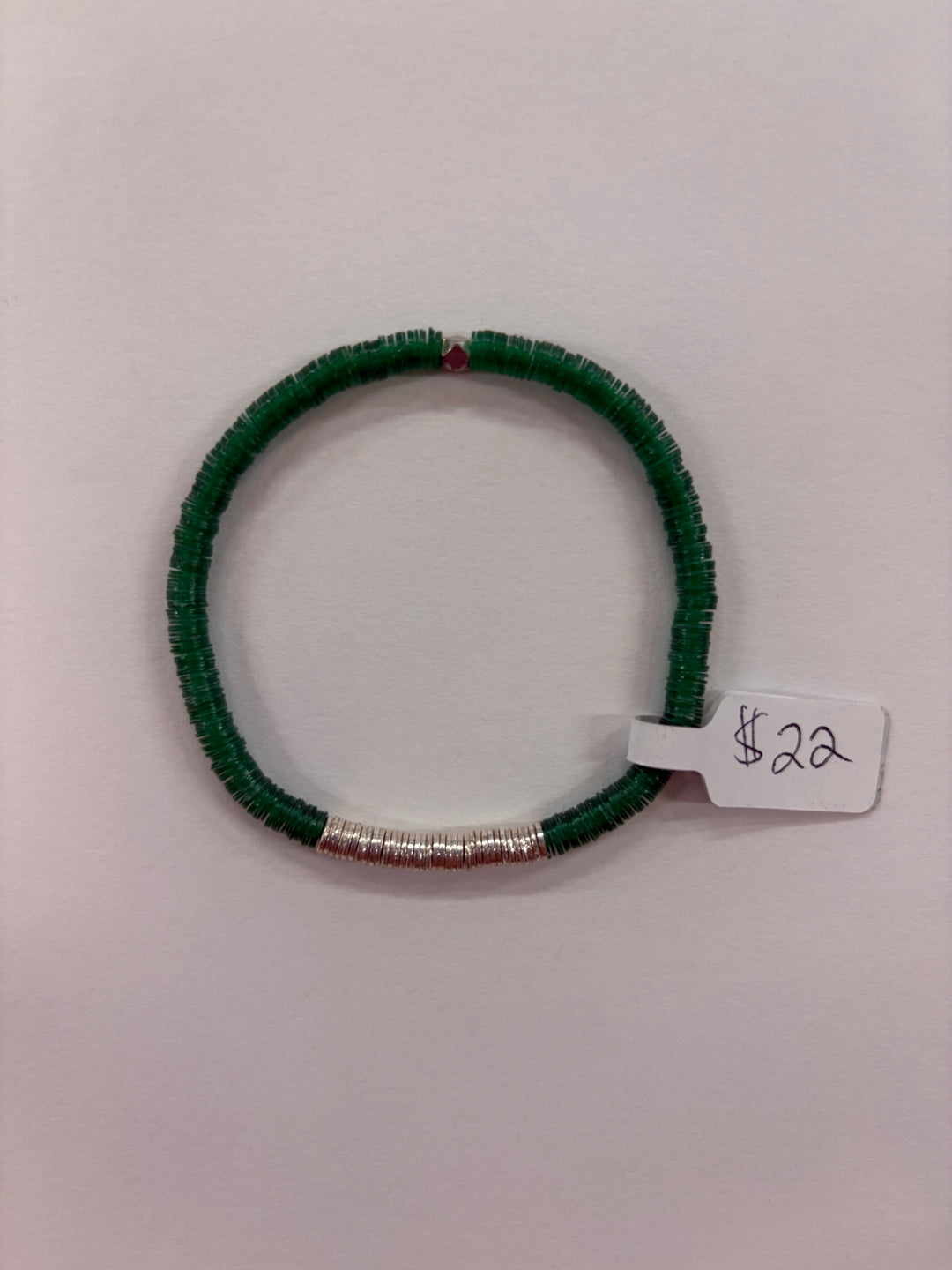 A green flat bead bracelet with a section of silver-plated beads and a single red bead.
