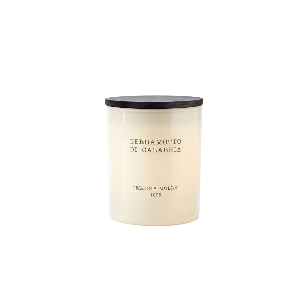 An ivory candle with a black lid, labeled "Bergamotto Di Calabria Céreria Mollá 1899".