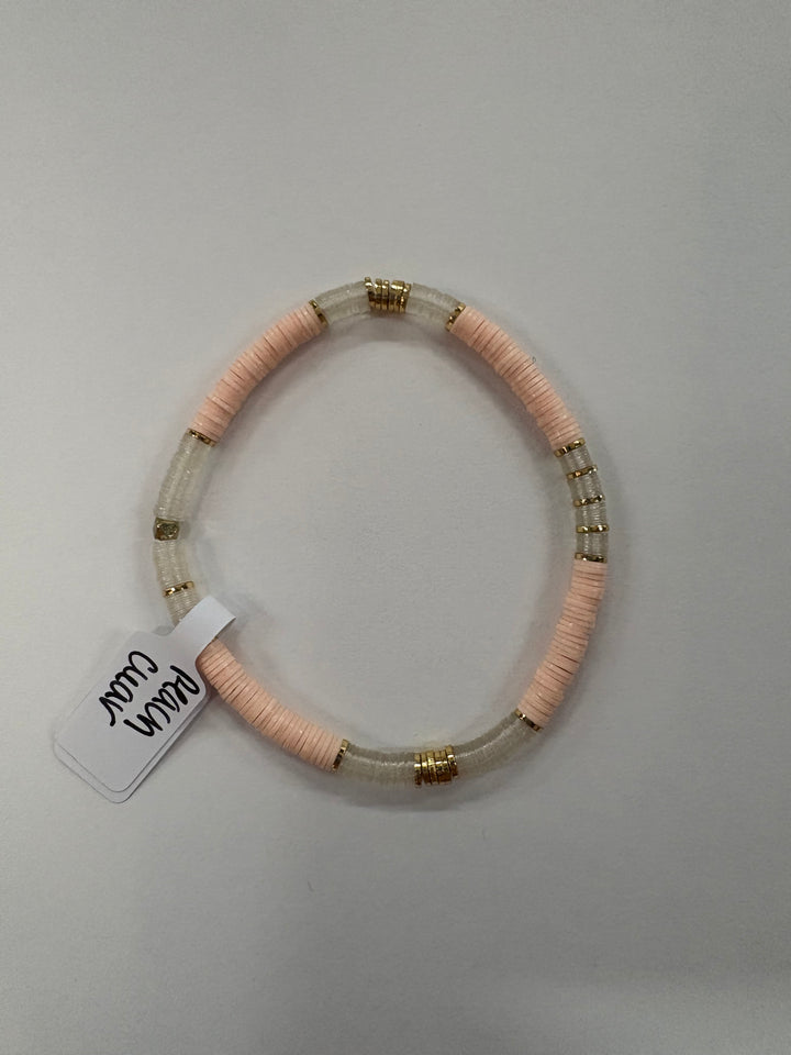 Small flat bead bracelet with peach and clear vinyl beads and gold accents.
