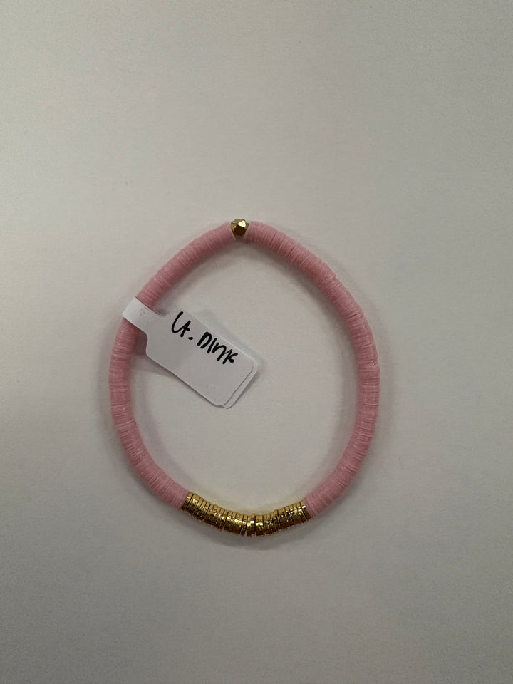 A light pink flat bead bracelet with a section of gold beads and a small gold bead at the top.