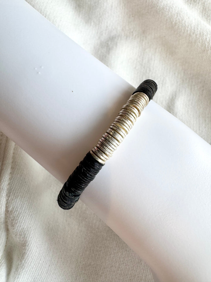 A large flat bead bracelet with silver-plated beads in the center and black vinyl beads on the sides.