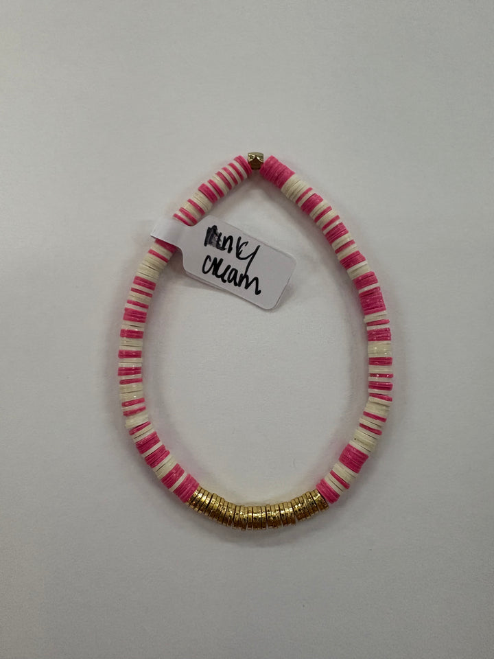 Small flat bead bracelet with alternating pink and cream vinyl beads and gold accents.
