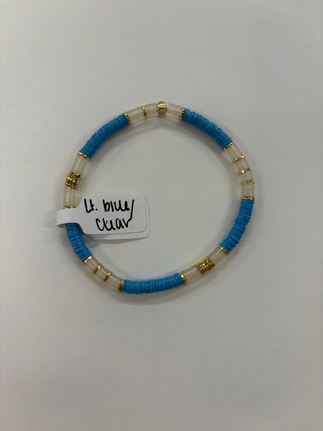 A light blue and clear flat bead bracelet with gold accents.