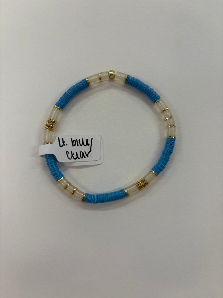 A light blue and clear flat bead bracelet with gold accents.