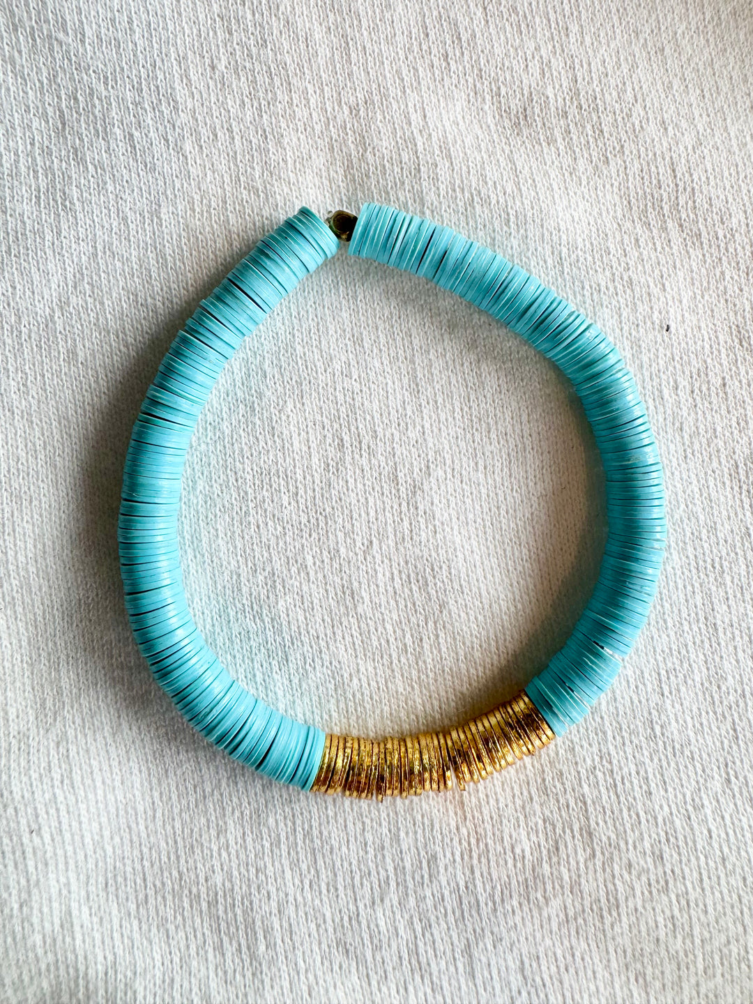 Large flat bead bracelet with turquoise vinyl beads and gold-plated accents.