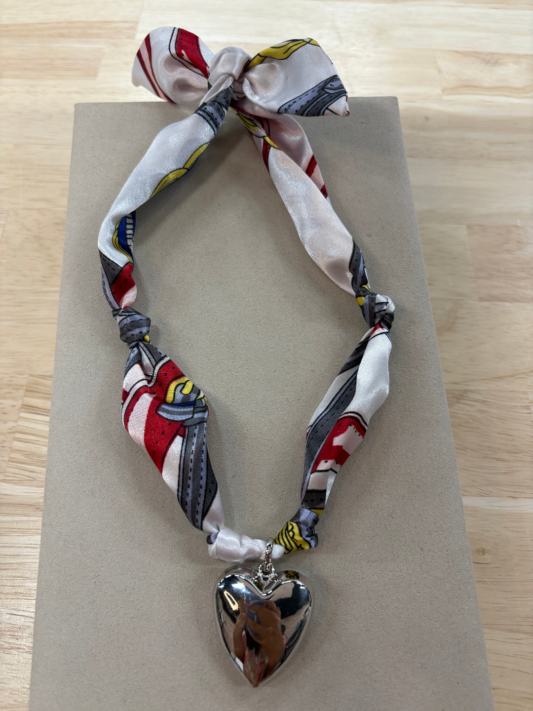 Emily Heart Satin Scarf Necklace with a silver heart charm.