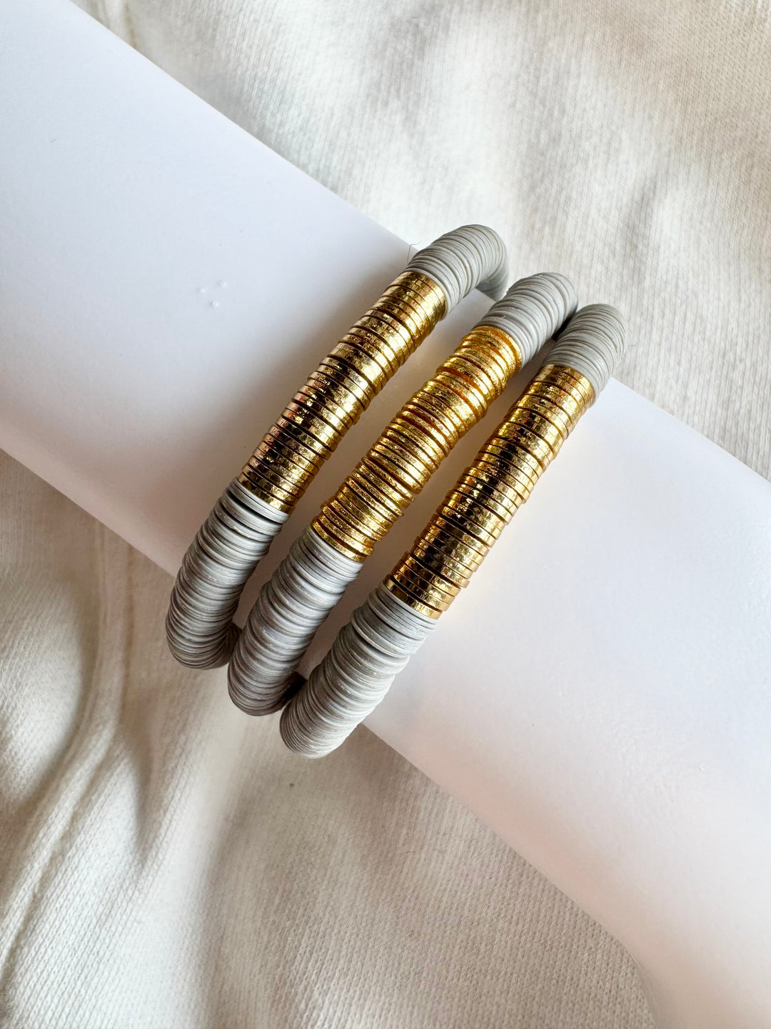 Three large flat bead bracelets with gold and gray vinyl beads are displayed on a white surface.