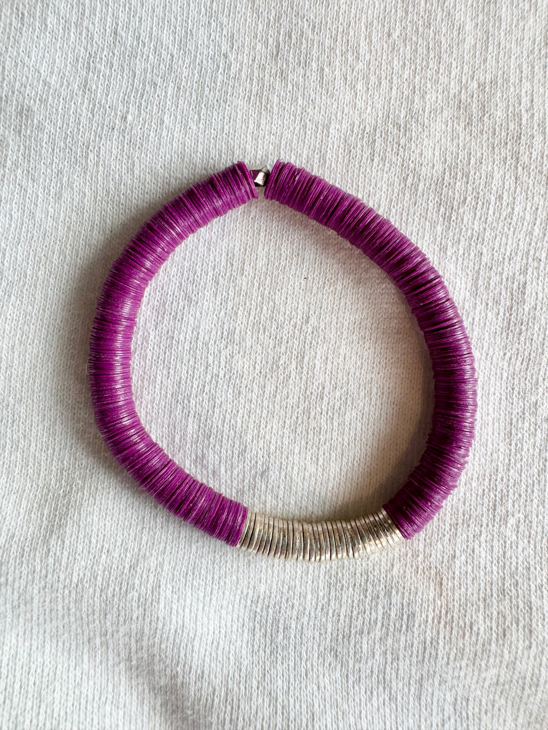 A large flat bead bracelet with purple vinyl beads and silver-plated accents.