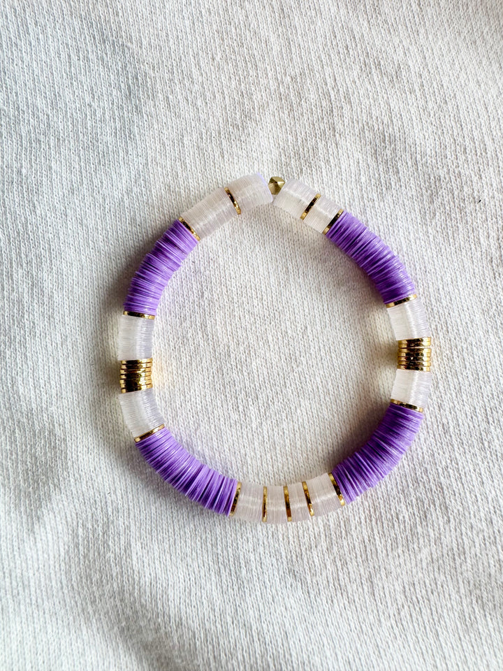 Large flat bead bracelet with purple and clear vinyl beads and gold spacers.