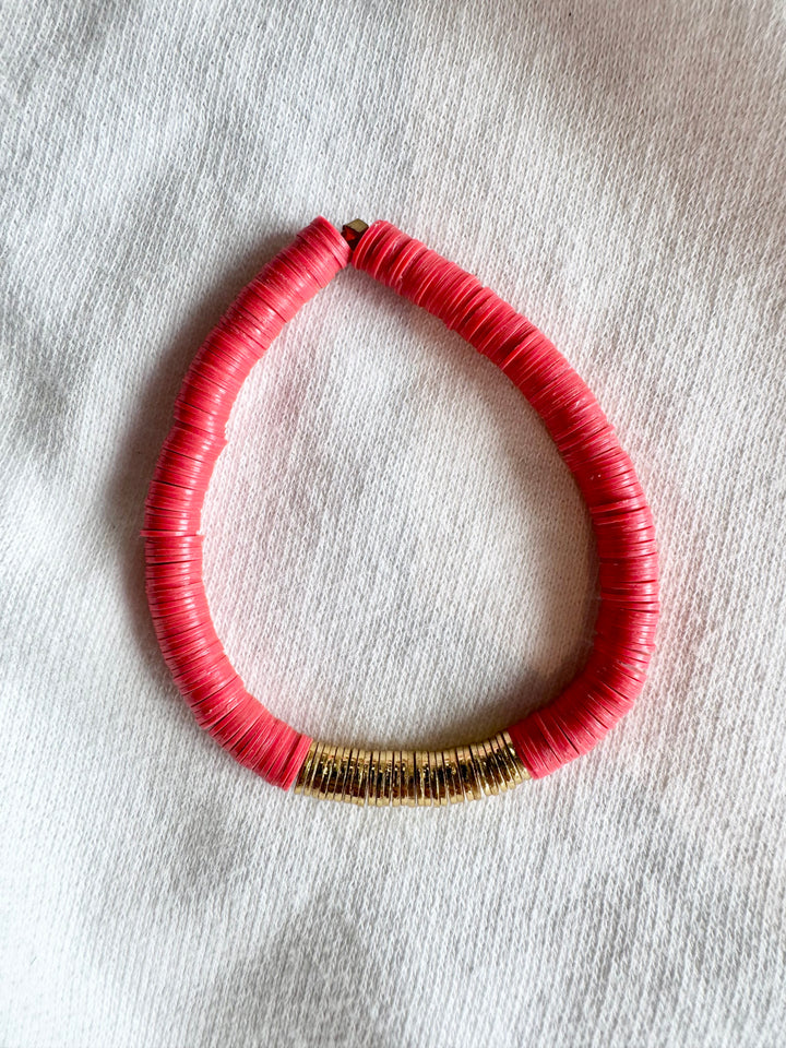 A coral flat bead bracelet with a section of gold-plated beads.