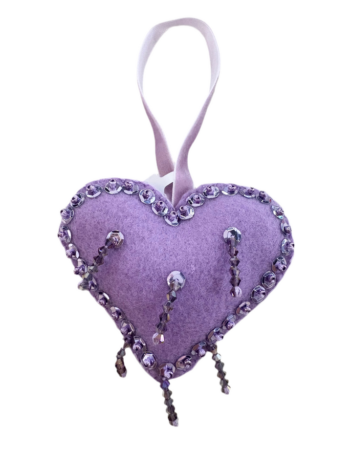 A purple heart-shaped ornament with a beaded border and dangling beads.