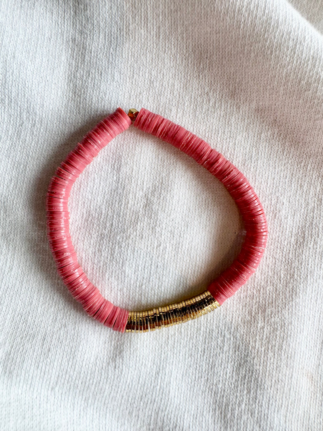 Large flat bead bracelet with pink vinyl beads and gold accents.