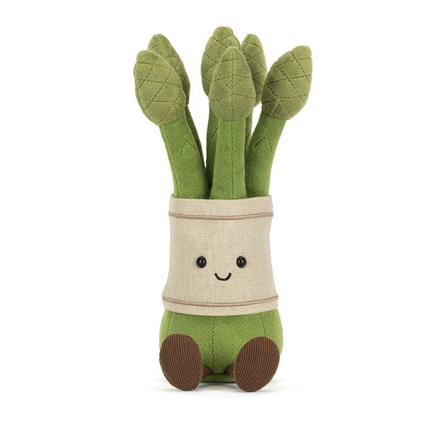 A plush toy asparagus with a smiling face and brown feet.
