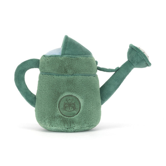A green plush watering can with a round emblem on the front.