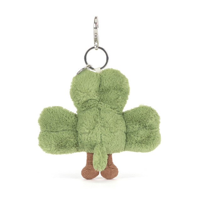 A green shamrock bag charm with brown feet and a silver clasp.