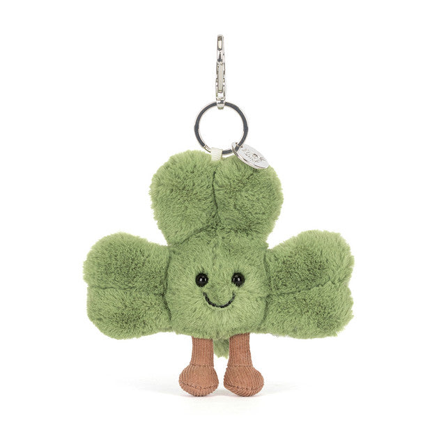 A green shamrock bag charm with brown corduroy boots and a silver clasp.