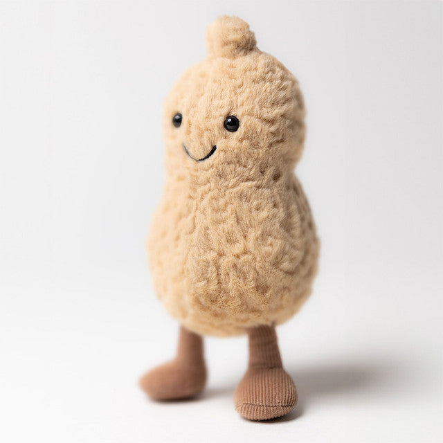 A plush peanut toy with a smiling face and small brown feet stands on a white background.