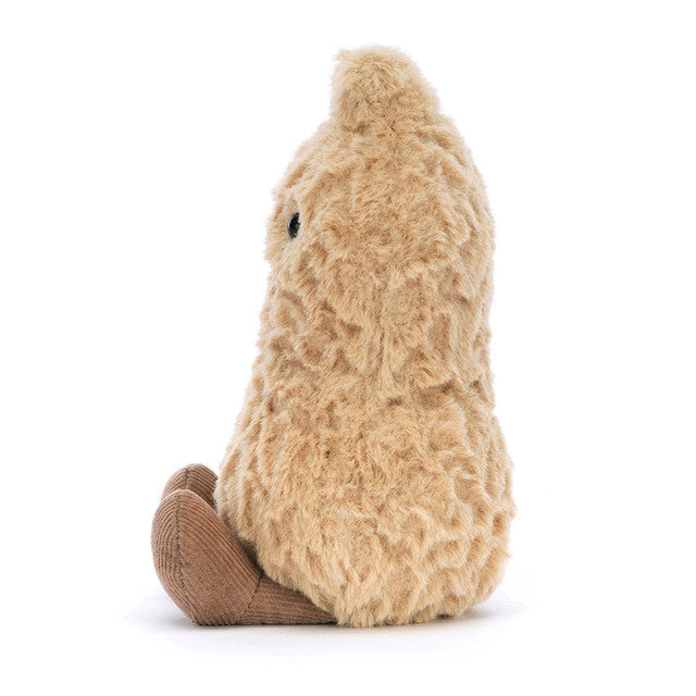 A plush peanut toy with a textured brown body and corduroy feet sits facing left.