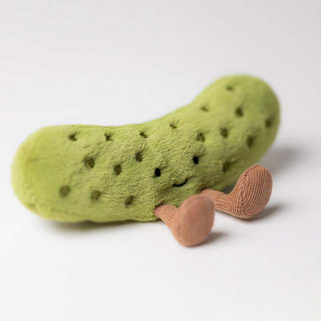 A plush pickle toy with embroidered eyes and brown corduroy feet.