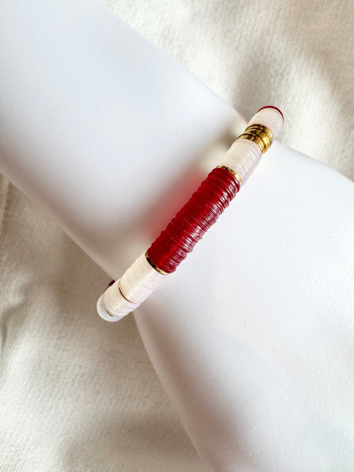 Large flat bead bracelet with red and white vinyl beads and gold accents.