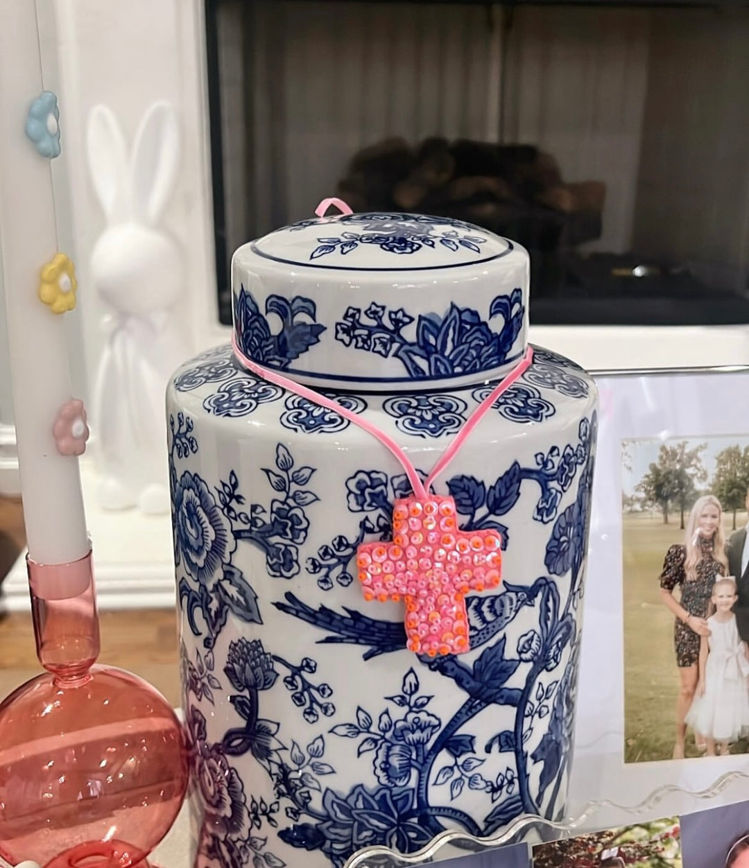 Mini Cross Hand Beaded Ornament, pink with orange accents, on a blue and white ginger jar.