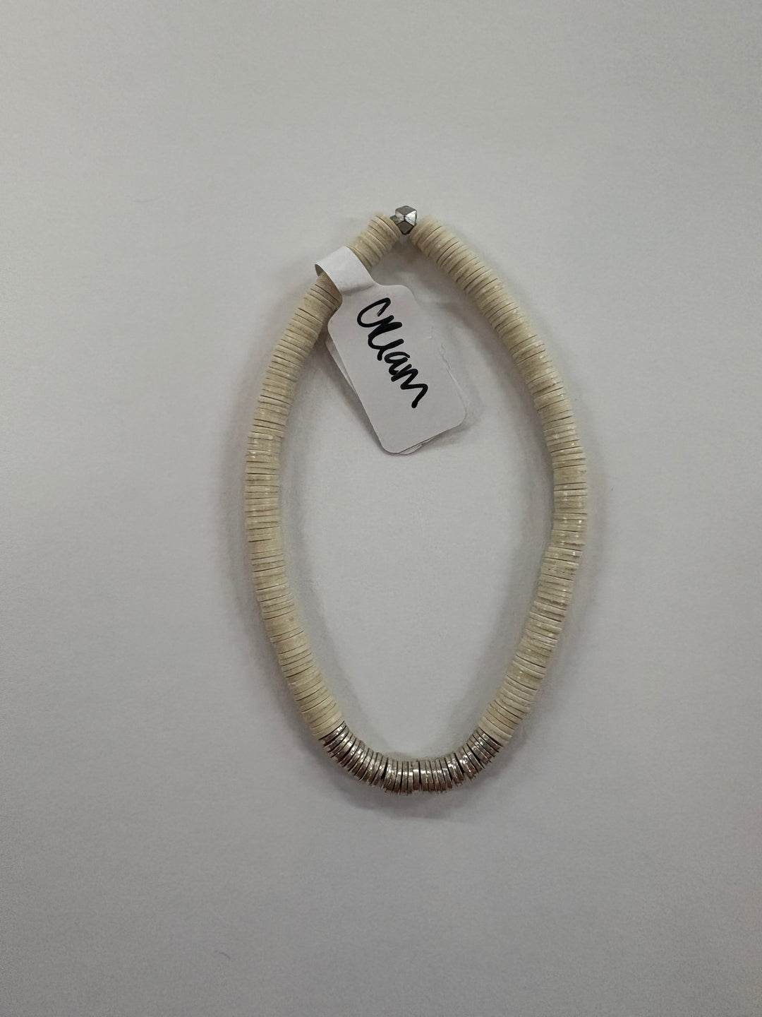 Small flat bead bracelet with a "Cream" tag and silver-toned accents.