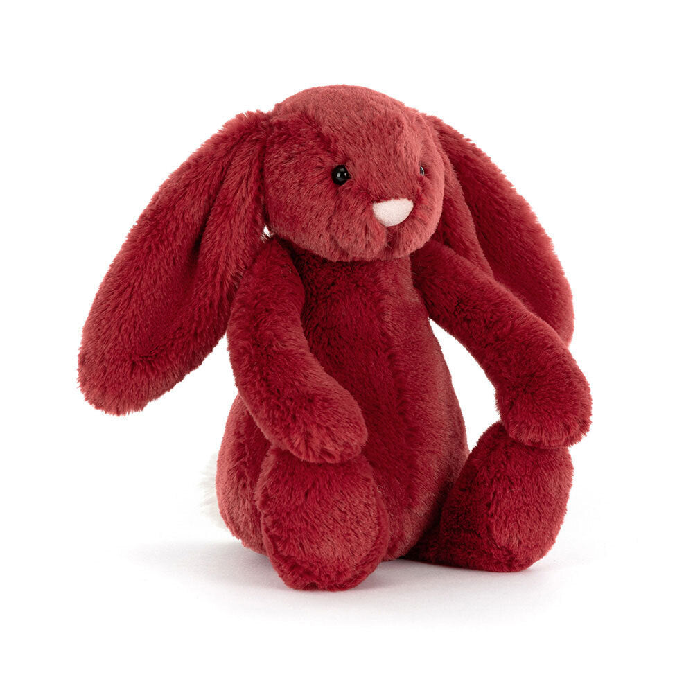 A redcurrant-colored plush bunny with long ears, a pink nose, and a white fluffy tail.