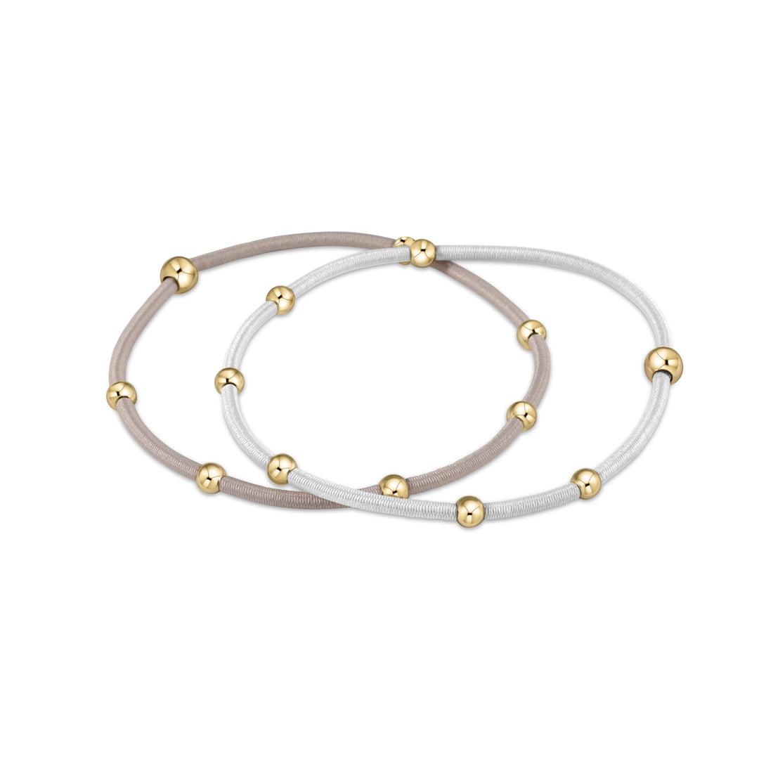 Two elastic hair ties, one beige and one white, with gold-filled beads.