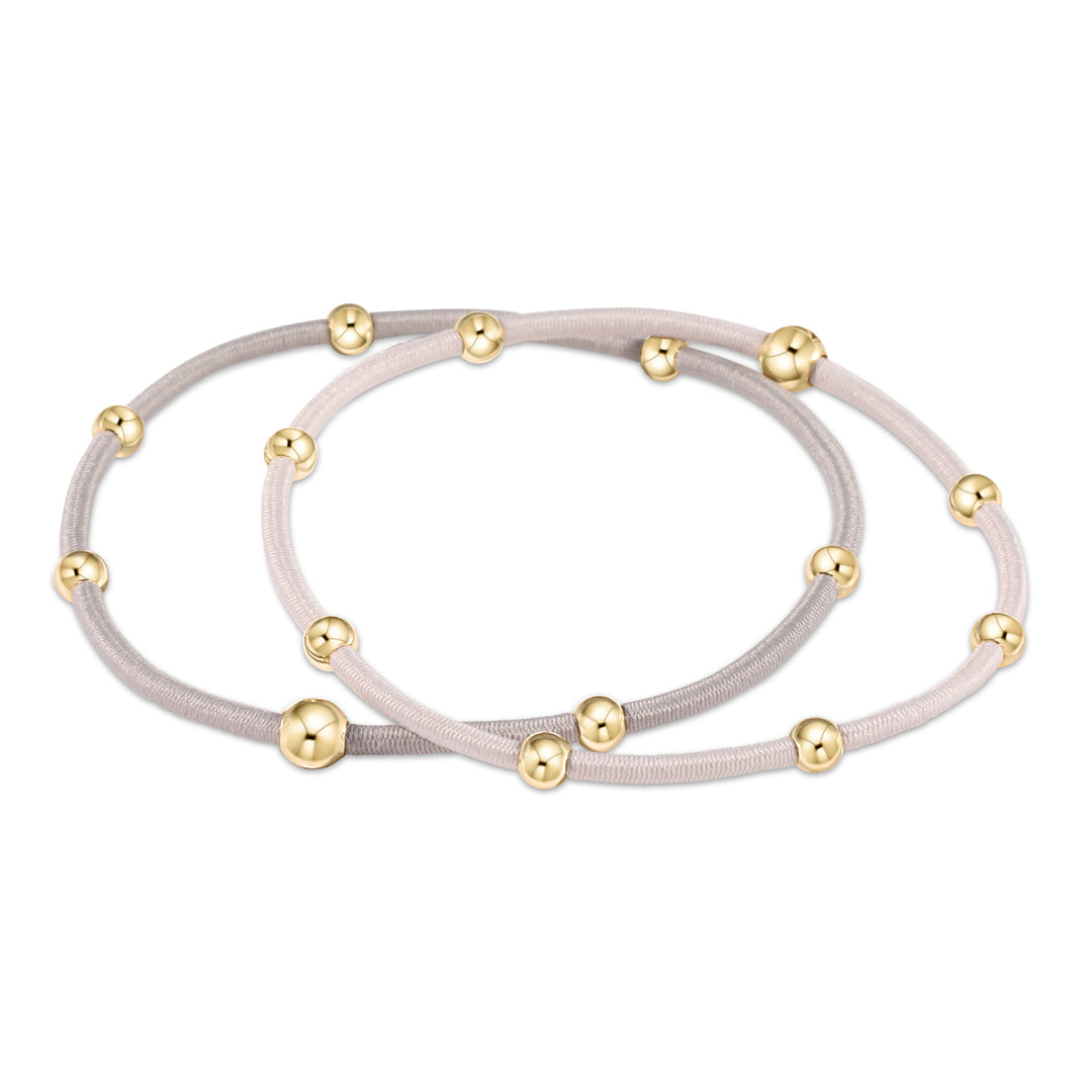 Two neutral-colored elastic hair ties with gold-filled beads.
