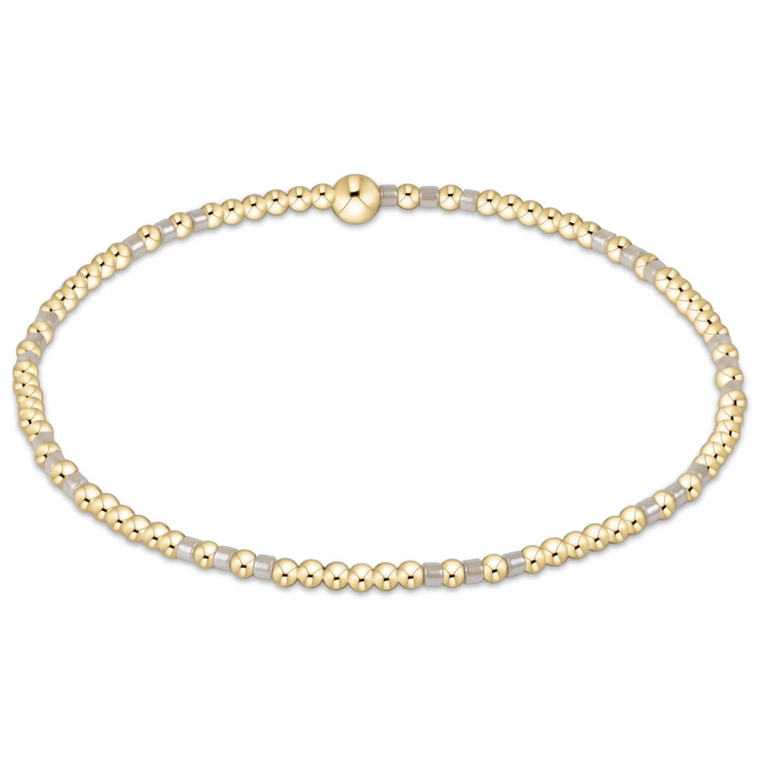 A gold bead bracelet with alternating clear beads.