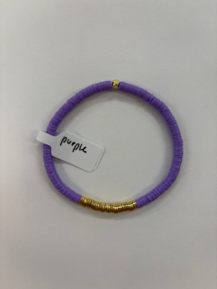 A purple flat bead bracelet with gold accents and a "purple" tag.
