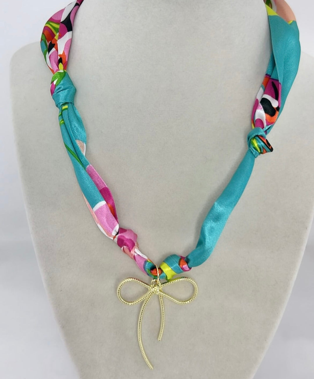 Avery Satin Scarf Necklace with a gold bow charm.