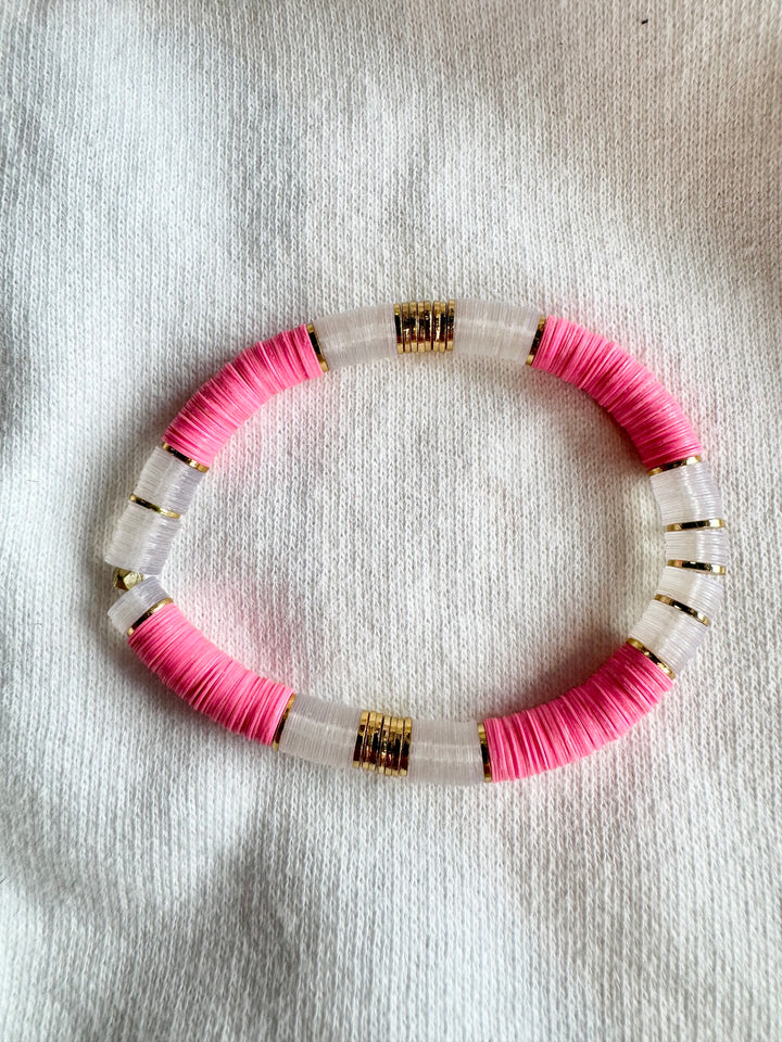 Large flat bead bracelet with pink and clear vinyl beads and gold accents.