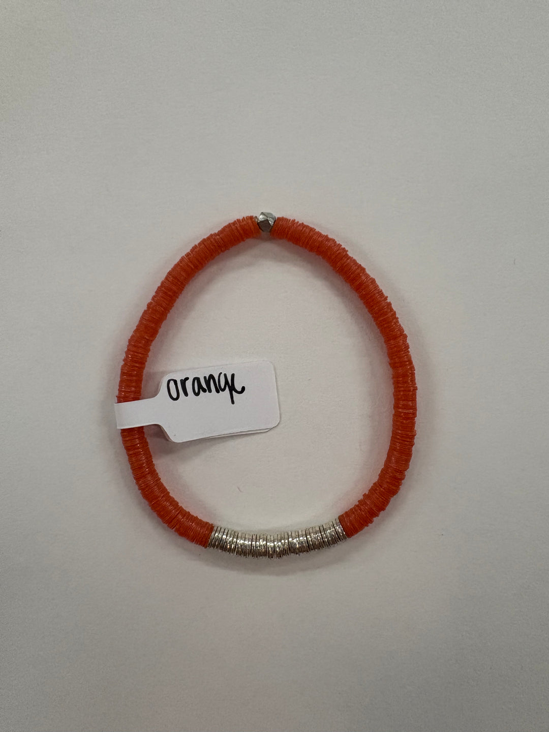 Small flat bead bracelet with orange vinyl beads and silver-plated accents.