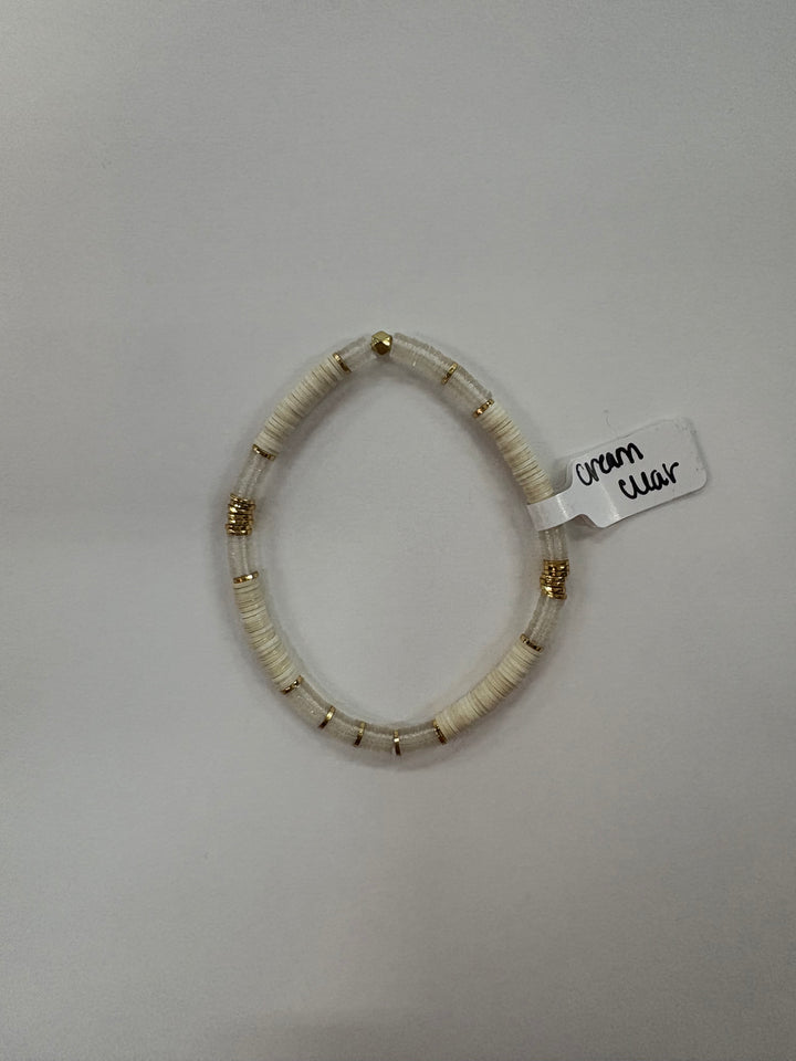Small flat bead bracelet with white and clear beads, and gold accents.