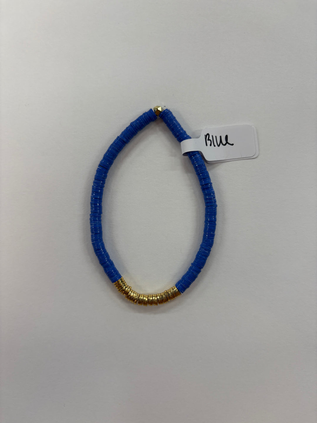 A blue flat bead bracelet with a section of gold beads and a tag that says "Blue."