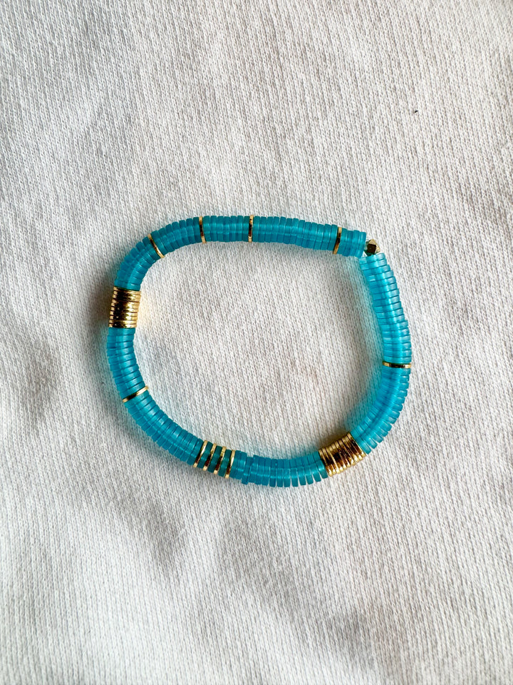 Large flat bead bracelet with turquoise vinyl beads and gold-plated accents.