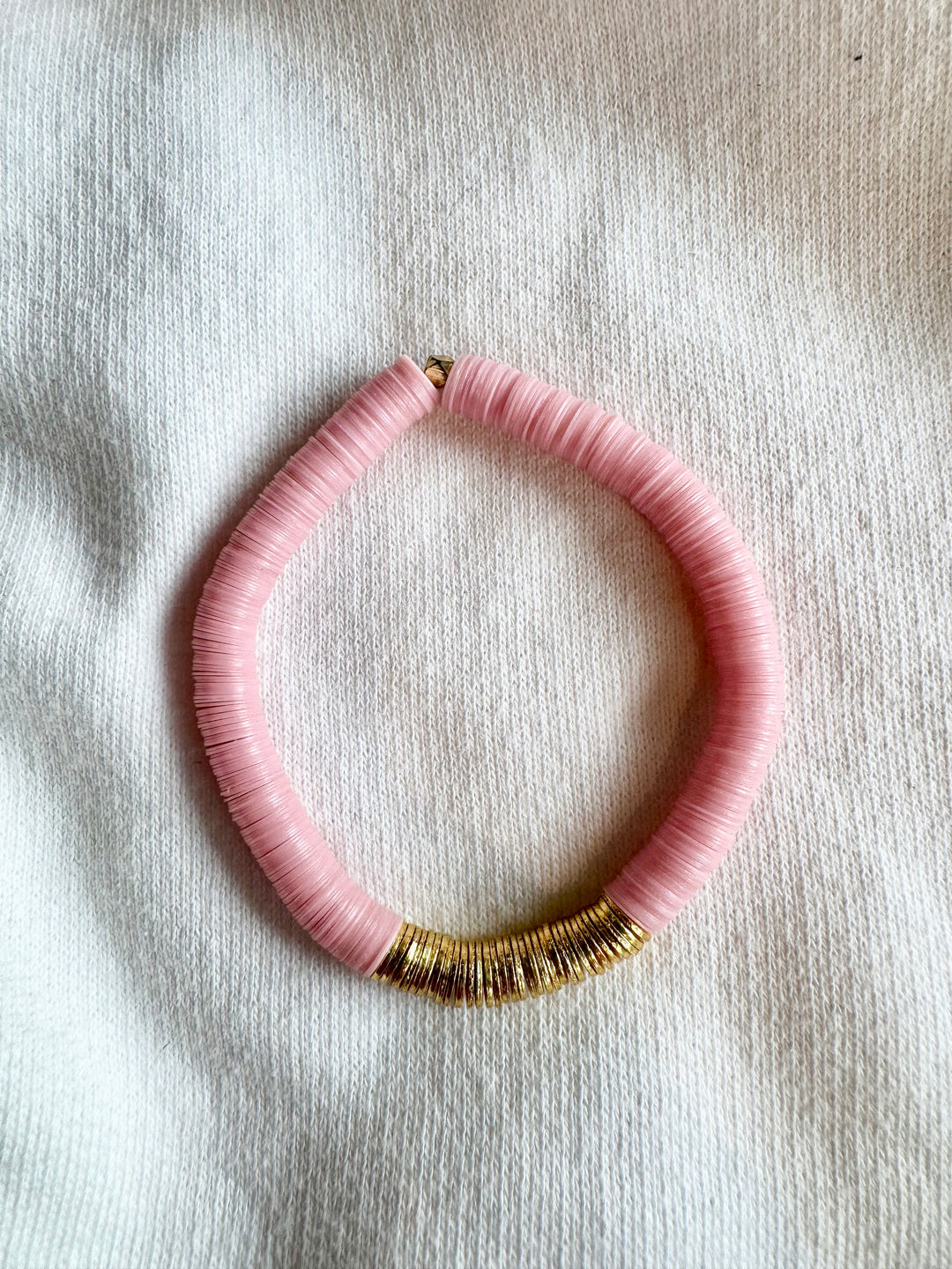 Large flat bead bracelet with pink vinyl beads and gold accents.